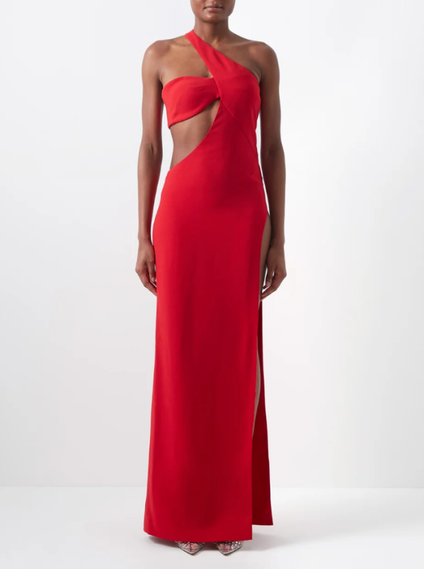 Eine Frau trägt ein rotes, asymmetrisches Abendkleid mit Schlitz.