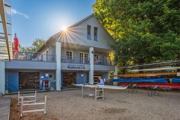 Ein Mann bereitet ein Ruderboot vor dem „Erster Wiener Ruderclub LIA“ vor.