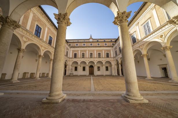 Der Innenhof des Palazzo Ducale in Urbino, Italien, mit Säulen und Arkaden.