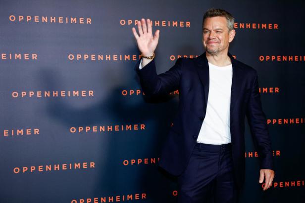 Matt Damon posiert vor einer Wand mit dem Schriftzug „Oppenheimer“.