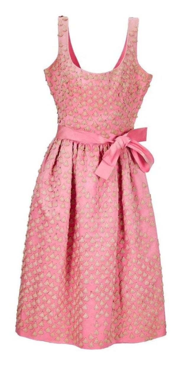 Ein ärmelloses, rosa Kleid mit Schleife und Muschelmuster.