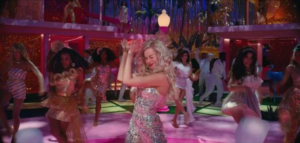 Margot Robbie tanzt mit anderen Darstellern in einer Szene aus dem Film „Barbie“.
