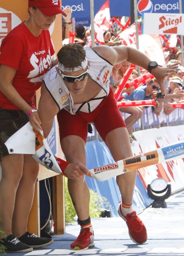Ein Triathlet durchbricht das Zielband beim Ironman-Wettbewerb.