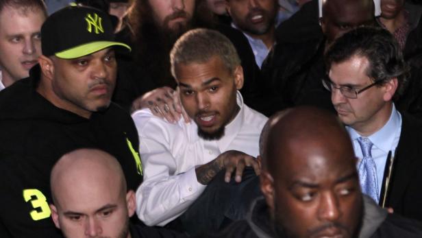 Chris Brown wird von mehreren Personen umringt.