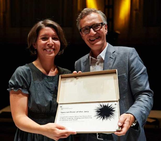 Eine Frau und ein Mann halten eine Auszeichnung mit der Aufschrift „Special Prize of the Jury“.