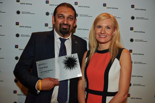 Ein Mann und eine Frau posieren mit einer Auszeichnung der Erste Stiftung für „Little People Romania“.