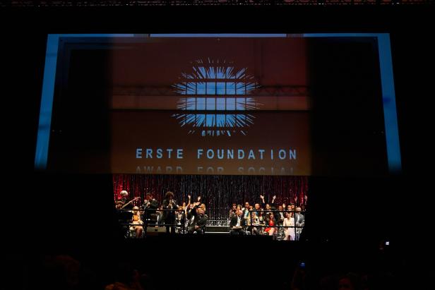 Eine Preisverleihung der Erste Foundation mit Publikum und Band auf der Bühne.