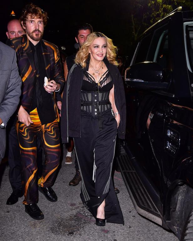 Madonna verlässt ein Gebäude in einem schwarzen Trainingsanzug und einem Korsett.