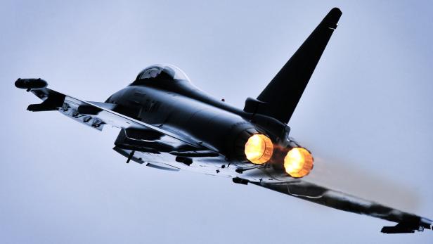 Ein Eurofighter Typhoon im Flug, dessen Triebwerke hell leuchten.