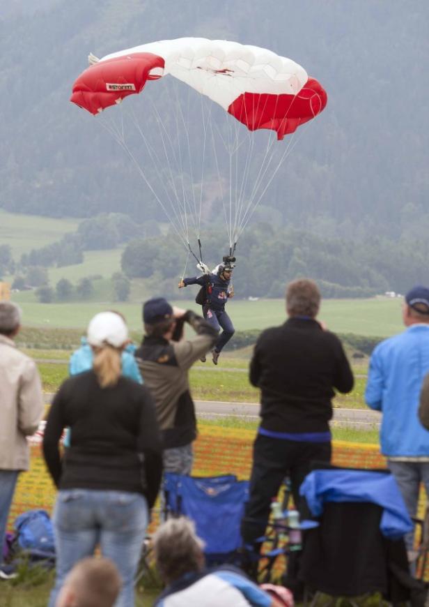 Ein Fallschirmspringer landet vor einer Zuschauermenge.