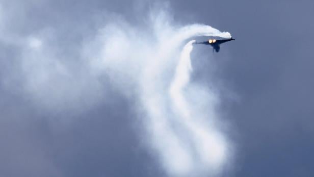 Ein Kampfjet zieht Kondensstreifen in den Himmel.