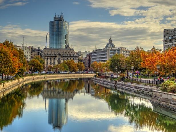 Blick auf Bukarest, Rumänien, mit einem Fluss und Herbstlaub.