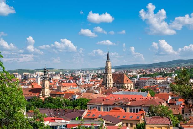 Blick über Cluj-Napoca, Rumänien, mit roten Dächern und Kirchtürmen.