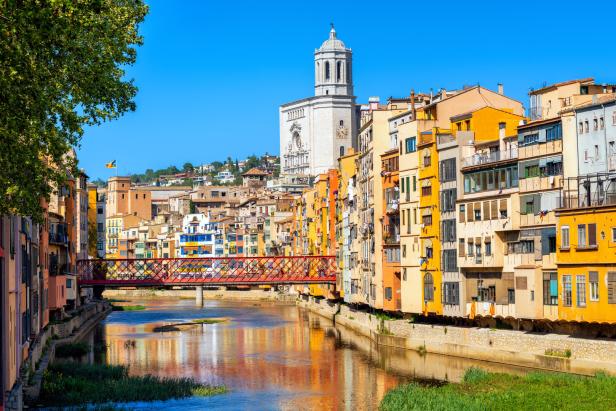 Blick auf Girona, Spanien, mit dem Fluss Onyar und bunten Häusern im Vordergrund.