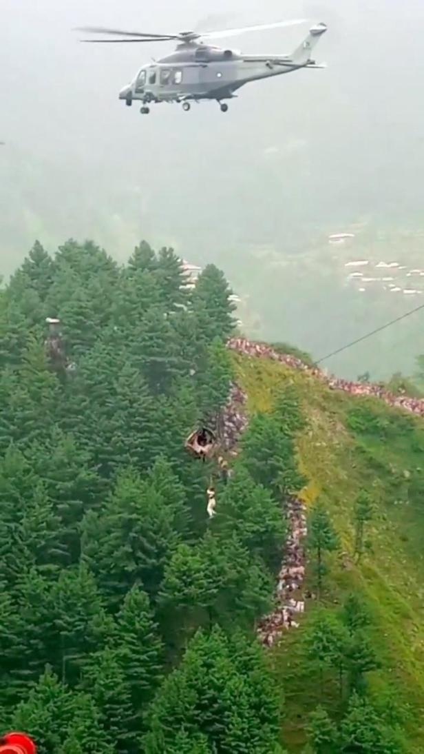 A helicopter rescues a person following a cable car with students stranded mid-air in Battagram