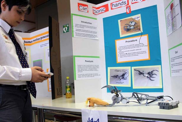 Ein Schüler präsentiert ein Projekt über bionische Hände auf einem Wissenschaftswettbewerb.