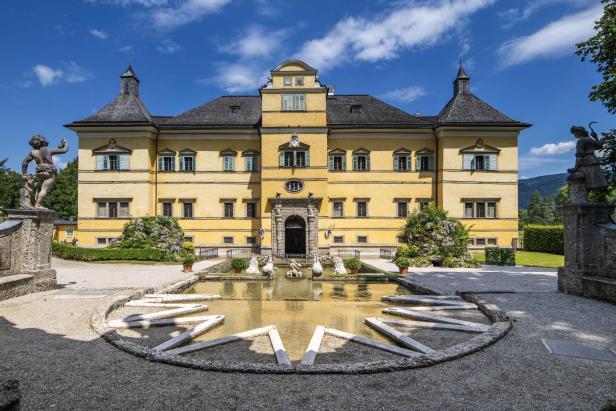 Schloss Hellbrunn in Salzburg mit einem Brunnen im Vordergrund.