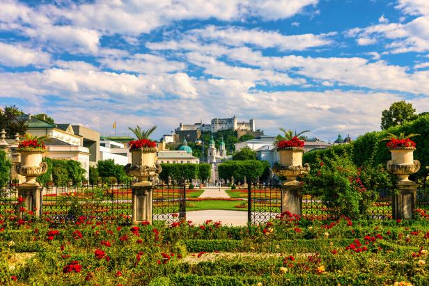 Die Festung Hohensalzburg überblickt einen blühenden Garten in Salzburg.