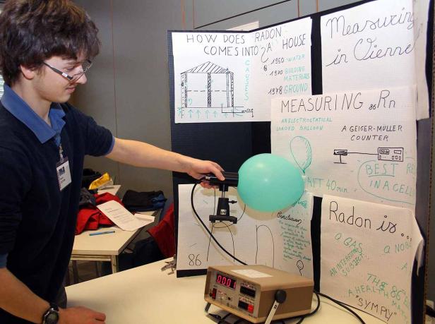 Ein junger Mann führt ein Radon-Experiment mit einem Ballon und Messgeräten durch.