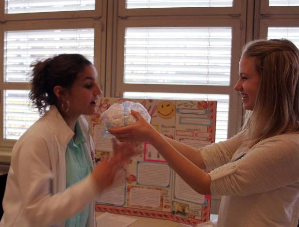 Zwei junge Frauen präsentieren ein wissenschaftliches Projekt.