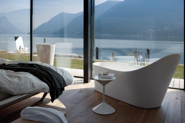 Eine Badewanne von Laufen (Modell Palomba) steht in einem Zimmer mit Seeblick.