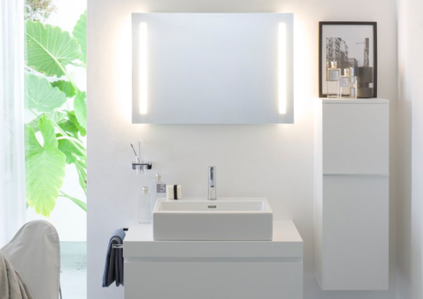 Ein modernes, weißes Badezimmer mit Waschbecken, Spiegel und Schrank von Laufen.