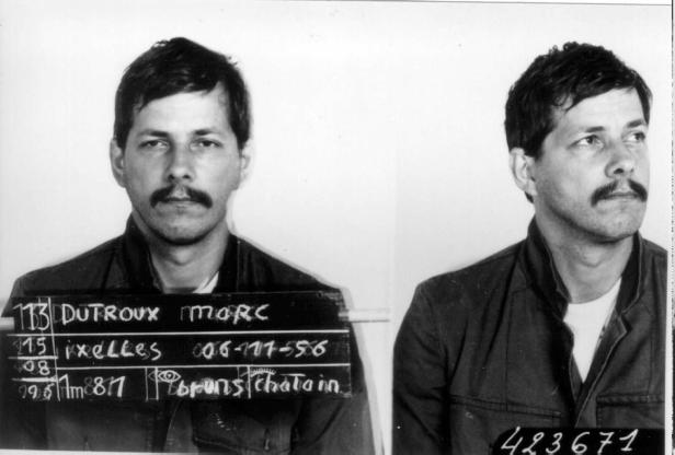 Ein Schwarzweißfoto von Marc Dutroux mit einem Schild, das seine Personalien enthält.
