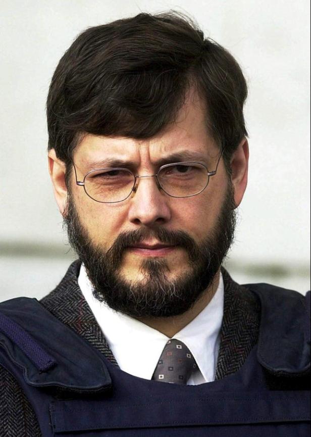 Porträt von Ramzi Yousef mit Brille und Bart, der eine kugelsichere Weste trägt.