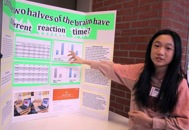 Ein junges Mädchen präsentiert eine wissenschaftliche Arbeit über Reaktionszeiten des Gehirns.