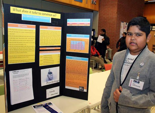 Ein Schüler steht vor einer Präsentation über menschliche Psychologie.