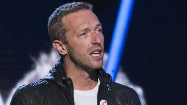 Chris Martin, der Sänger von Coldplay, spricht in ein Mikrofon.