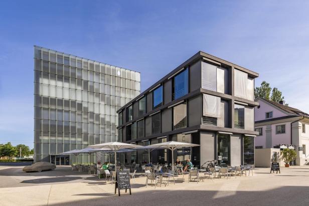 Das Kunsthaus Bregenz und ein Café im Freien an einem sonnigen Tag.