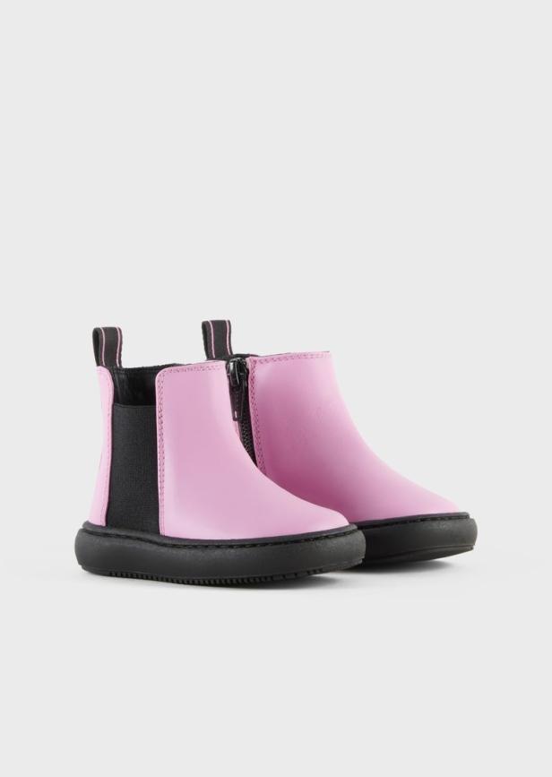 Ein Paar rosa Kinderstiefeletten mit schwarzen Sohlen stehen vor einem neutralen Hintergrund.