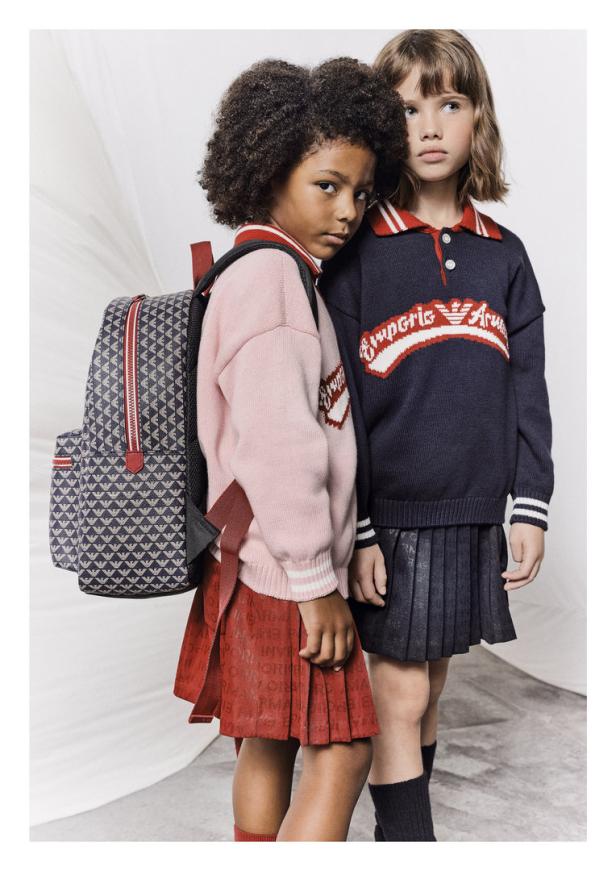 Zwei Mädchen posieren in Kleidung von Emporio Armani mit einem Rucksack.