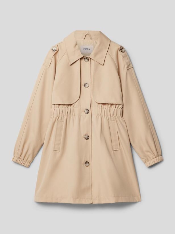 Ein beigefarbener Trenchcoat der Marke „Only“ vor einem grauen Hintergrund.