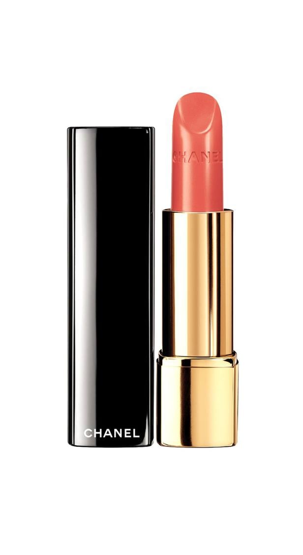 Ein geöffneter, korallfarbener Lippenstift von Chanel steht vor seinem schwarzen Deckel.