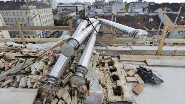 Auf einem Dach liegen Trümmer und neue Edelstahlrohre.