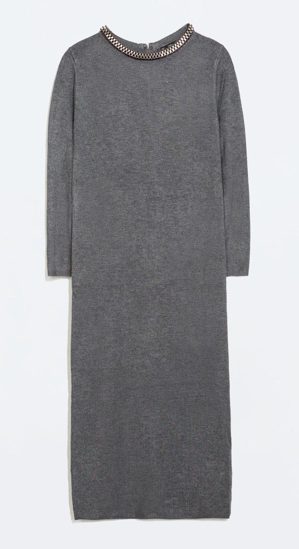 Ein graues Strickkleid mit einem goldenen Kettenkragen.