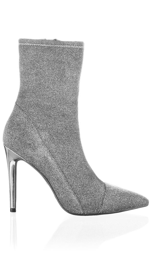 Ein silberner, glitzernder Stiefel mit hohem, dünnem Absatz.