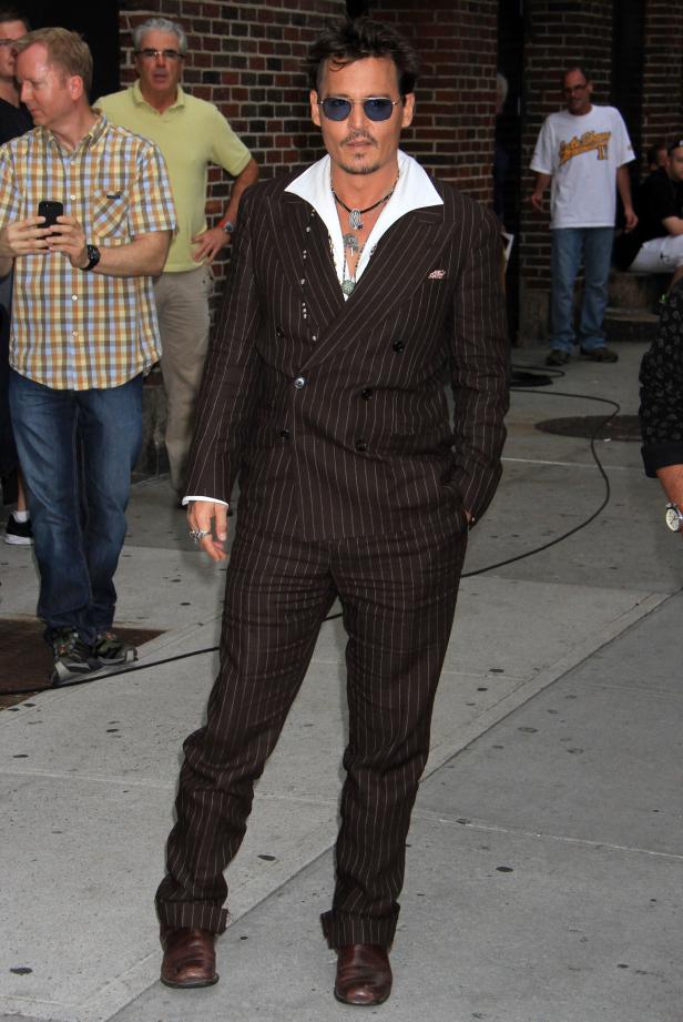 Johnny Depp in einem braunen Nadelstreifenanzug und blauen Sonnenbrille.