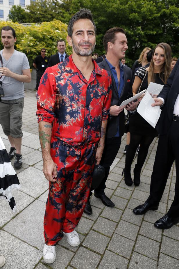Marc Jacobs trägt einen roten Pyjama-Anzug mit dunklen Mustern.