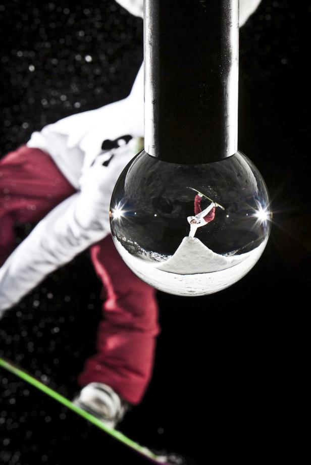 Ein Snowboarder macht einen Trick, gesehen durch eine Kristallkugel.