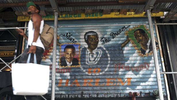 Ein Mann geht an einem Wandbild in Harlem vorbei, das Obama, Mandela und Martin Luther King zeigt.