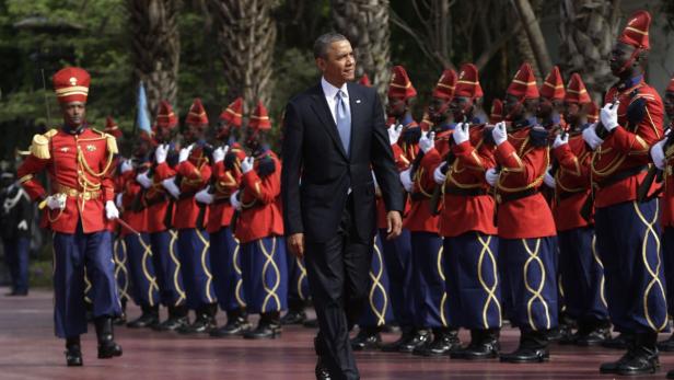 Barack Obama schreitet vor einer Ehrengarde in roten Uniformen ab.