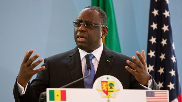 Macky Sall, der Präsident Senegals, gestikuliert vor senegalesischen und amerikanischen Flaggen.