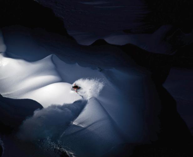 Ein Skifahrer fährt eine schneebedeckte Piste hinunter.