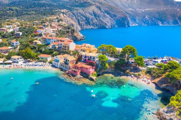 Luftaufnahme von Assos, Kefalonia, mit bunten Häusern und türkisfarbenem Wasser.