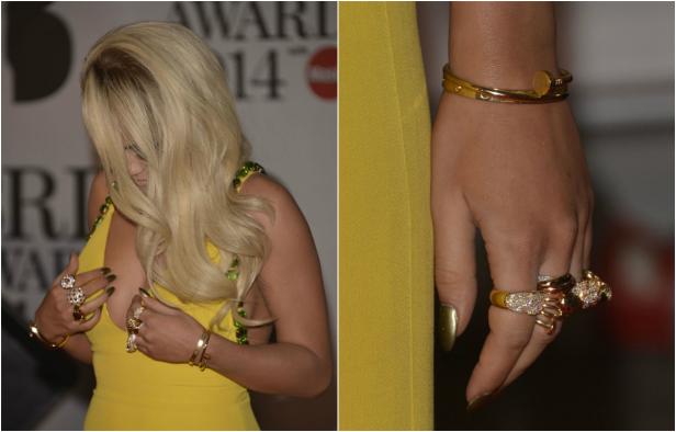 Eine Frau in einem gelben Kleid mit auffälligem Schmuck an Händen und Handgelenken.