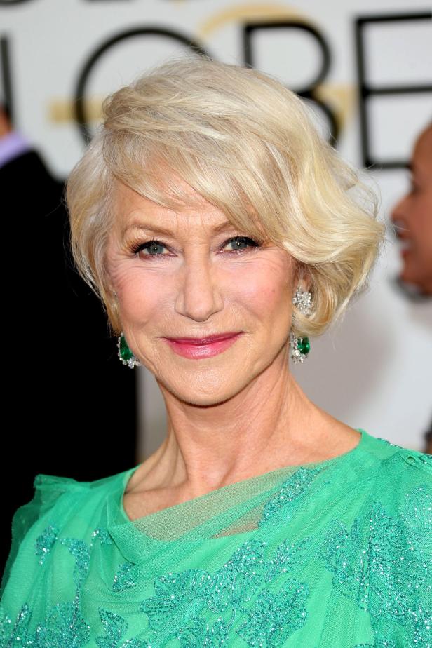 Helen Mirren mit kurzem, blondem Haar und grünen Ohrringen auf dem roten Teppich.