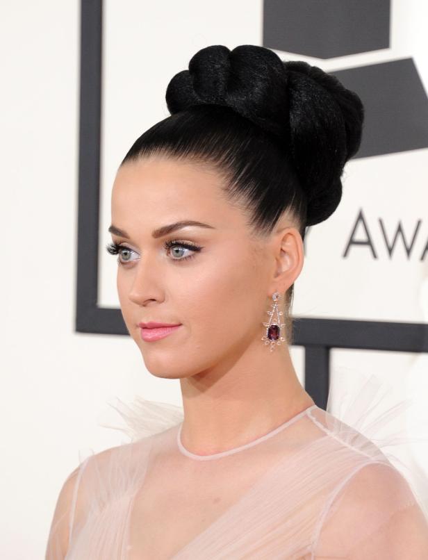 Katy Perry mit einem hochgesteckten Dutt und baumelnden Ohrringen.